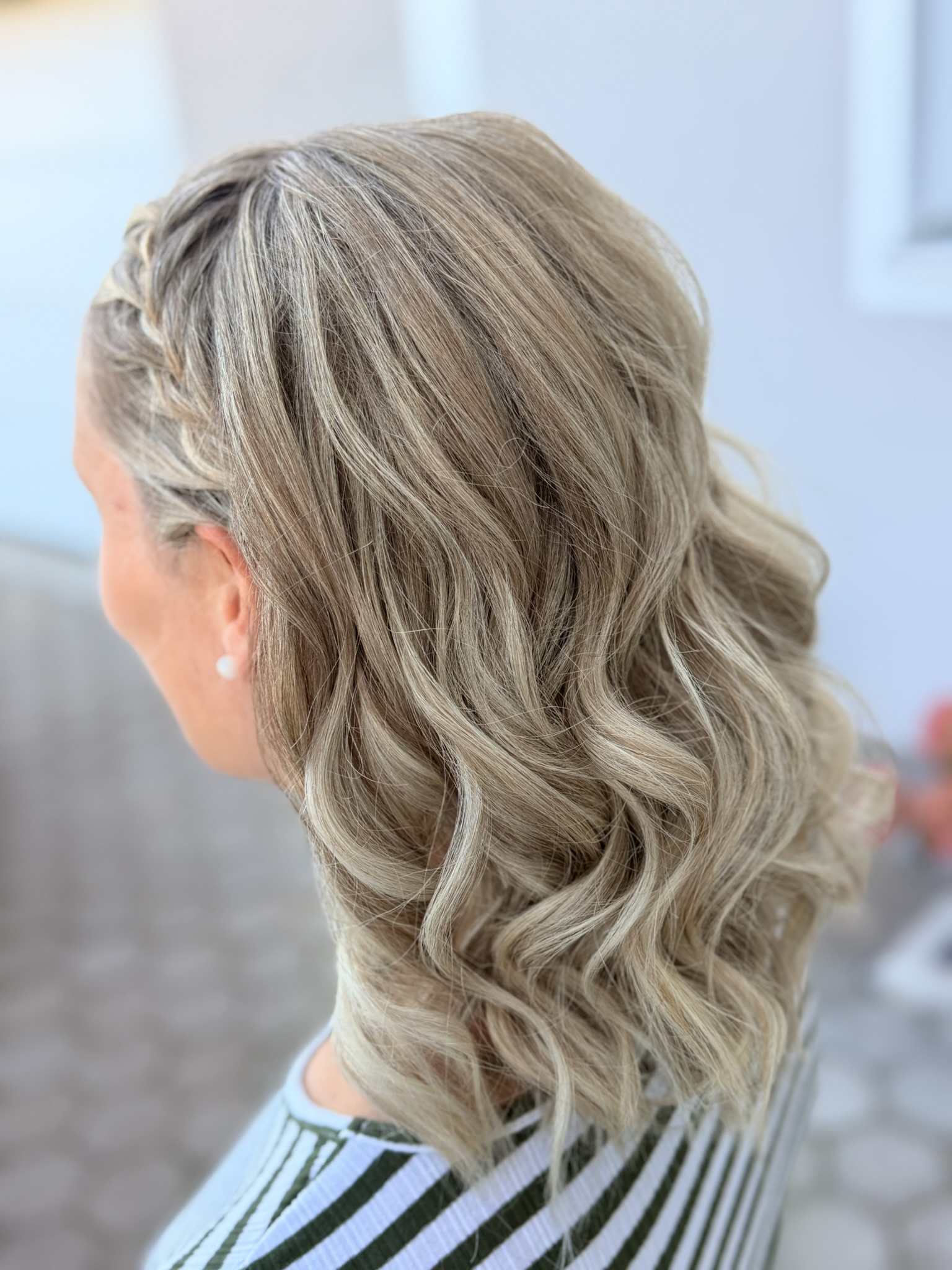 Lockere blonde Wellen mit seitlichem Zopf