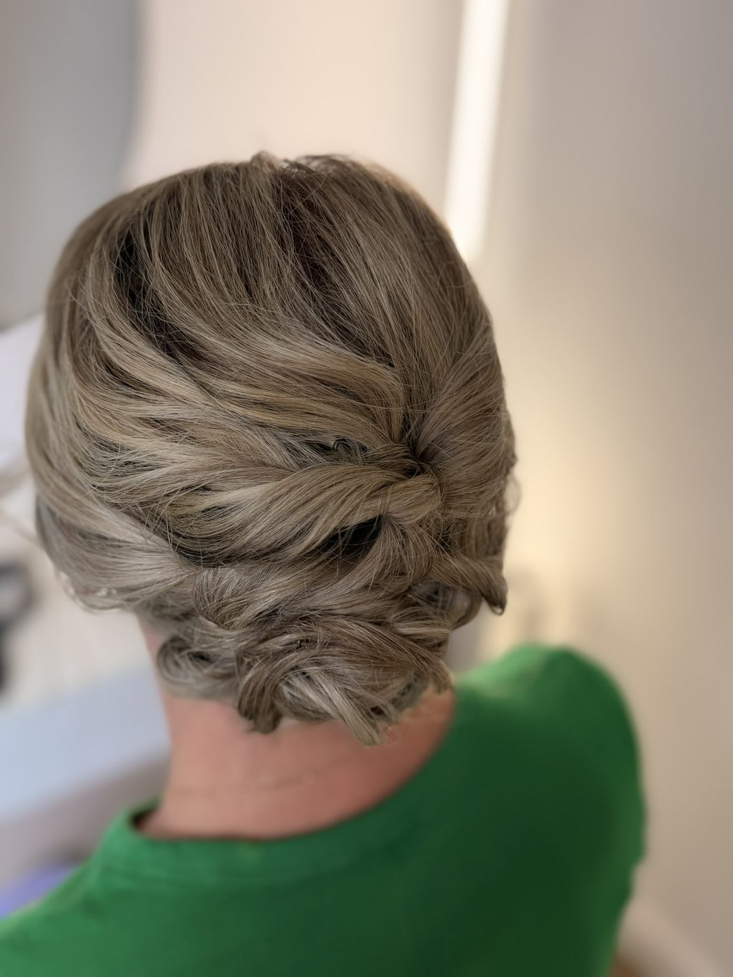 Blonde gedrehte Hochsteckfrisur von hinten