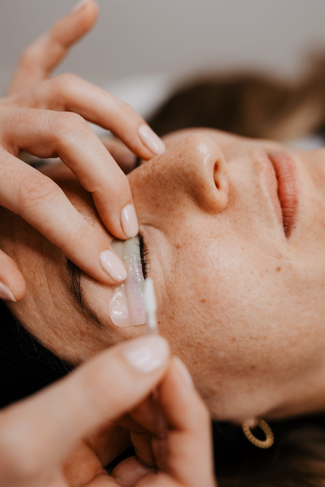 Wimpern werden beim Wimpernlifting mit einem Stäbchen auf dem Silikonpad gelegt