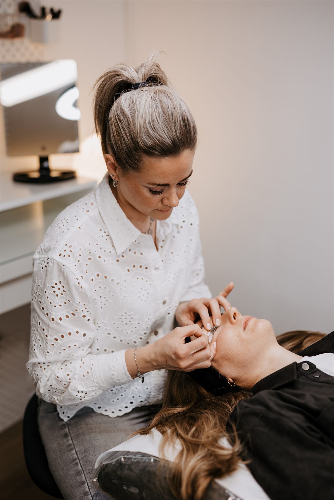 Marina setzt das Wimpernlifting am geschlossenen Auge an