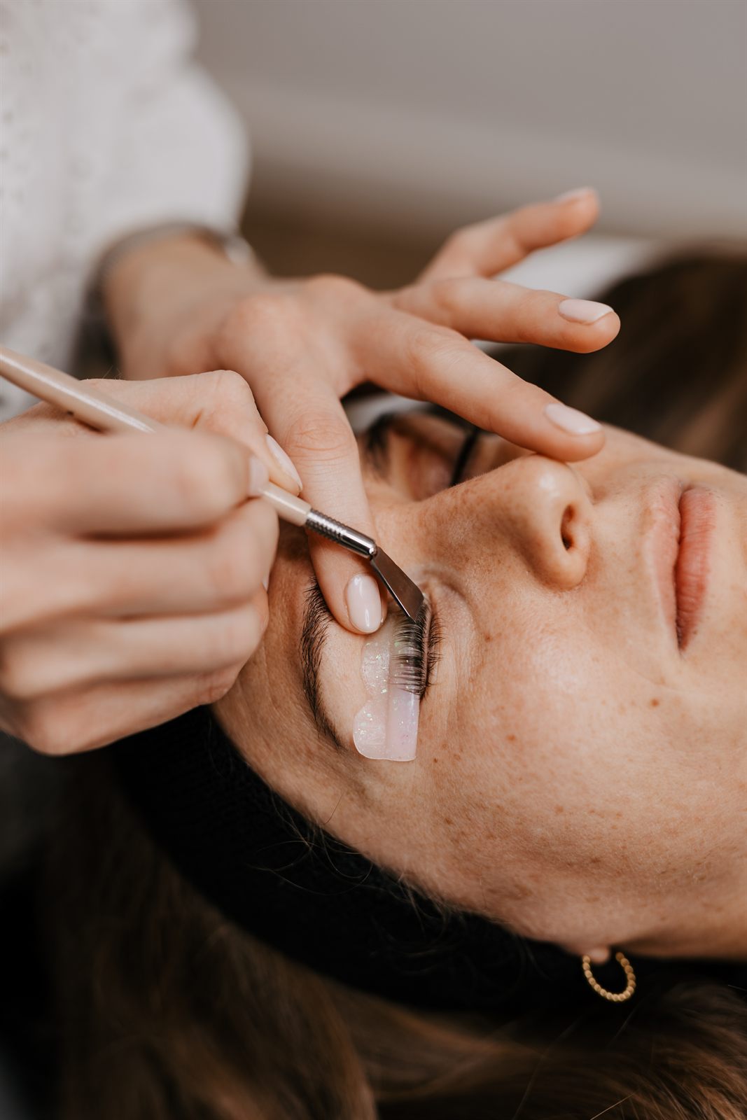 Wimpern werden beim Wimpernlifting mit einem Kamm auf dem Pad gerichtet