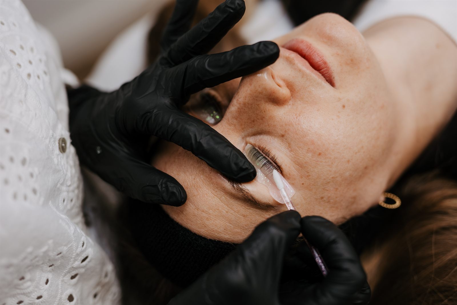 Lösung wird beim Wimpernlifting mit einem Stäbchen auf die Wimpern gegeben