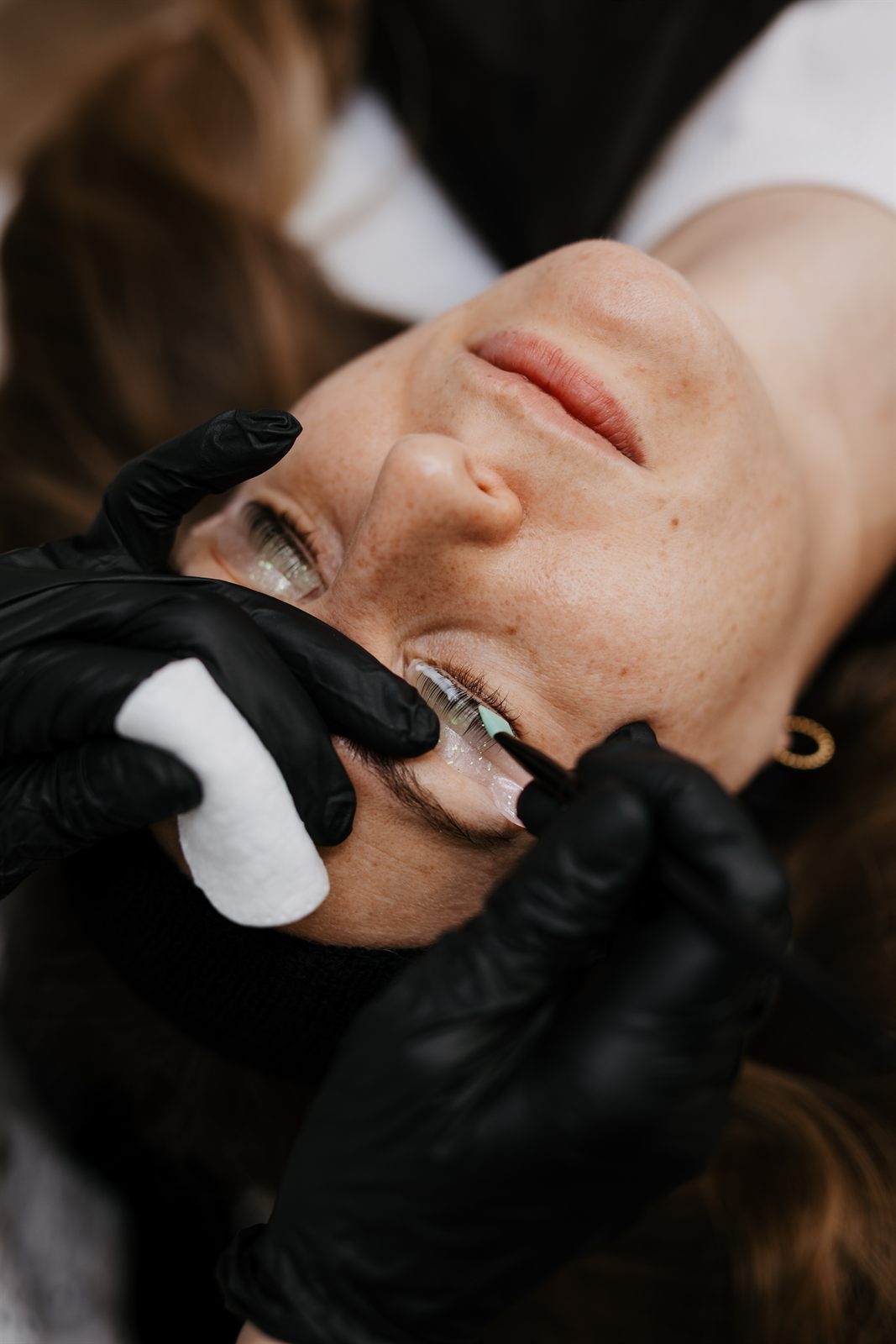 Überschüssige Lösung wird beim Wimpernlifting mit einem Pad abgenommen