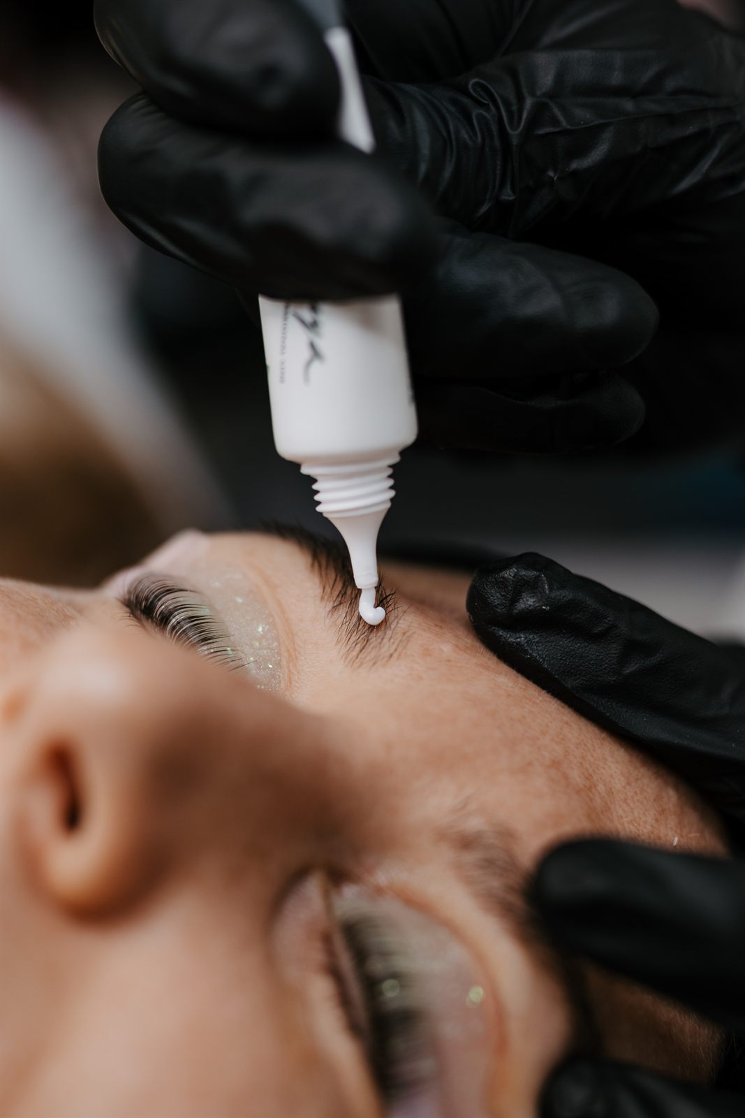 Brauenfarbe wird beim Browlifting aus der Tube auf die Augenbraue gegeben