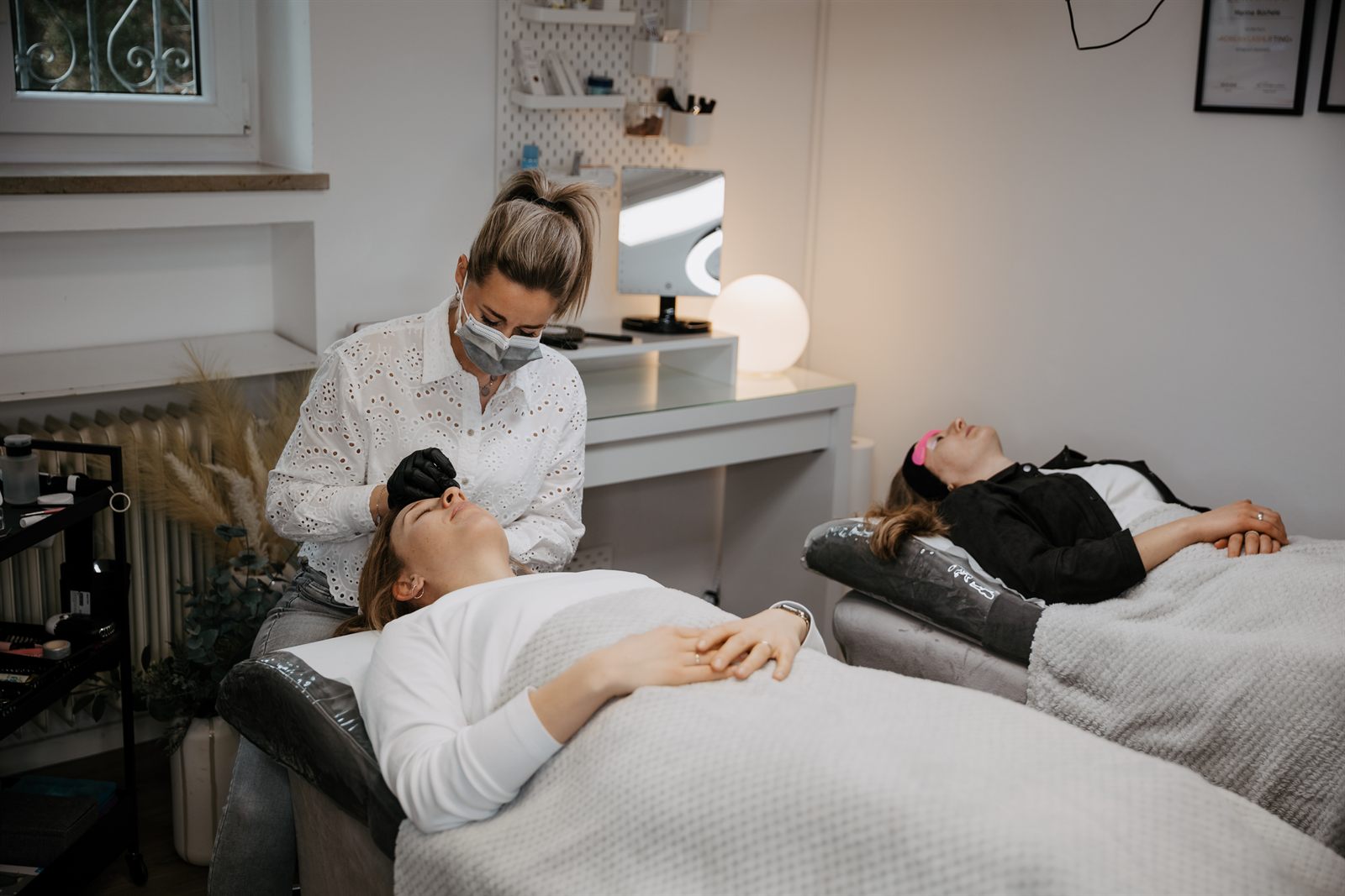 Wimpernlifting während der Behandlung bei Facestyling by marina, zwei Kundinnen liegen im Studio in Hollenbach